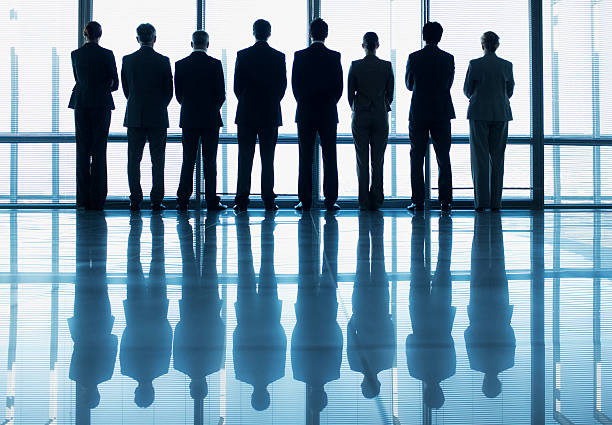 Groupe d'individus alignés et vus de dos 