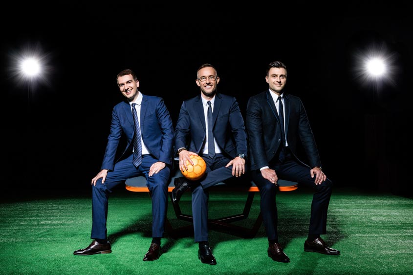 Trois hommes qui posent avec un ballon